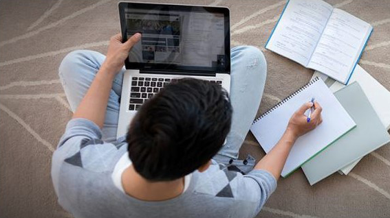 Jongen met laptop oriënteert zich online